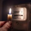 Candle in front of electric meter